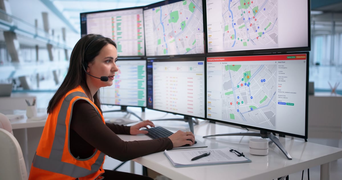 Dispatcher wearing a headset coordinating urgent medical courier runs from a computer